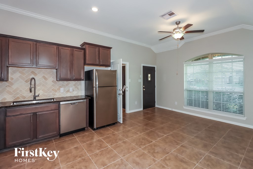 an empty kitchen with stainless steel appliances and tile flooring