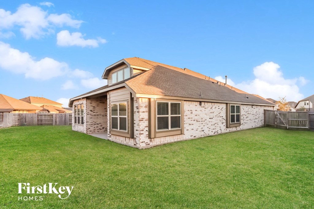 a small brick house with a grassy backyard