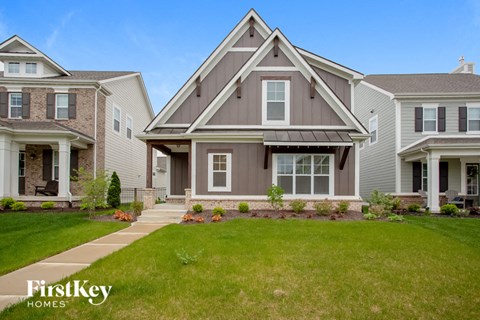 two story house with gray siding and a green lawn