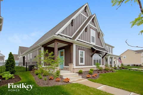 a house with a front porch and a green lawn