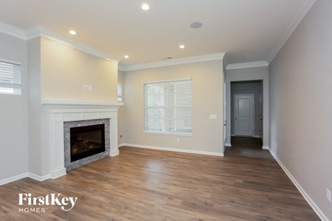 a living room with a fireplace and wooden floors