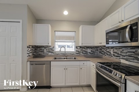 a kitchen with white cabinets and stainless steel appliances