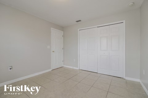 a bedroom with two closets and a tiled floor