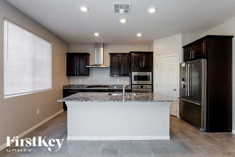A kitchen with a granite countertop and stainless steel appliances.