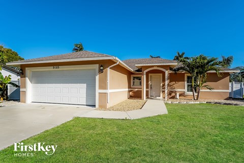 A house with a garage and a driveway in front of it.
