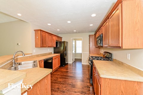 A kitchen with wooden cabinets and a stove top oven.