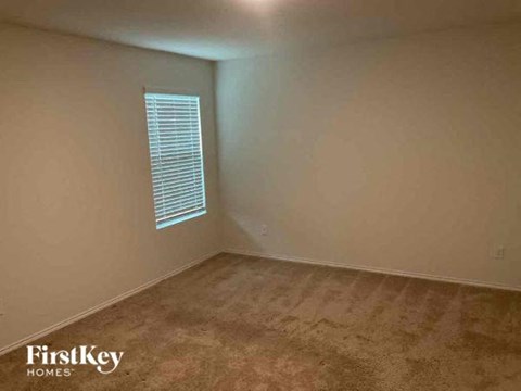 A room with a window and carpeted floor.