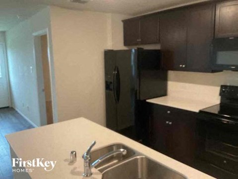 A kitchen with a sink and a refrigerator.