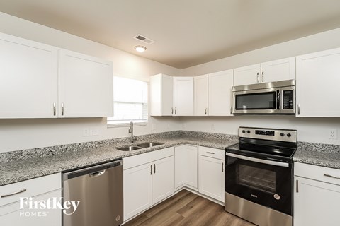 A kitchen with white cabinets and stainless steel appliances.