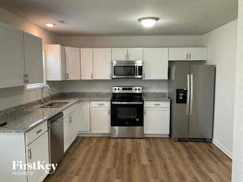 A kitchen with white cabinets and stainless steel appliances.