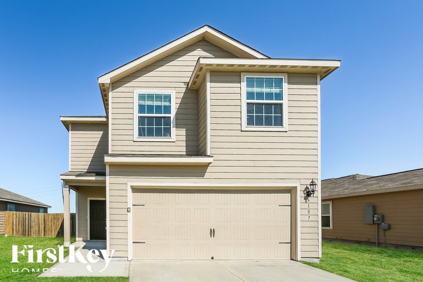 A two-story house with a garage is showcased in the image.