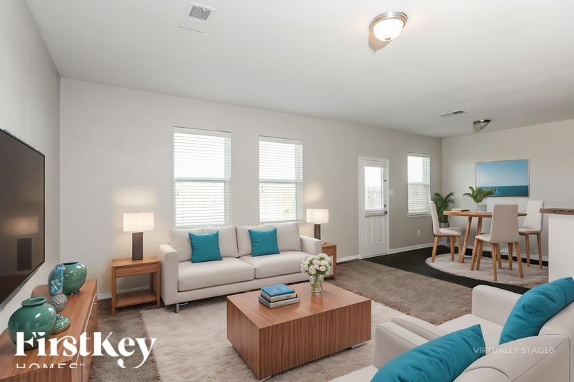 A well-lit living room with a white sofa and a wooden coffee table.