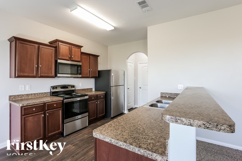 A kitchen with brown cabinets and a granite countertop.