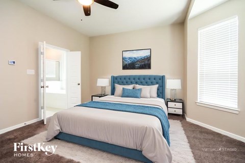 A bedroom with a large bed and a ceiling fan.
