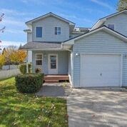 a white house with a garage and a driveway