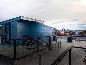 a blue shed on a roof with a city in the background