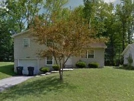 A house with a tree in front of it.