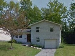 A house with a garage and a driveway in front of it.