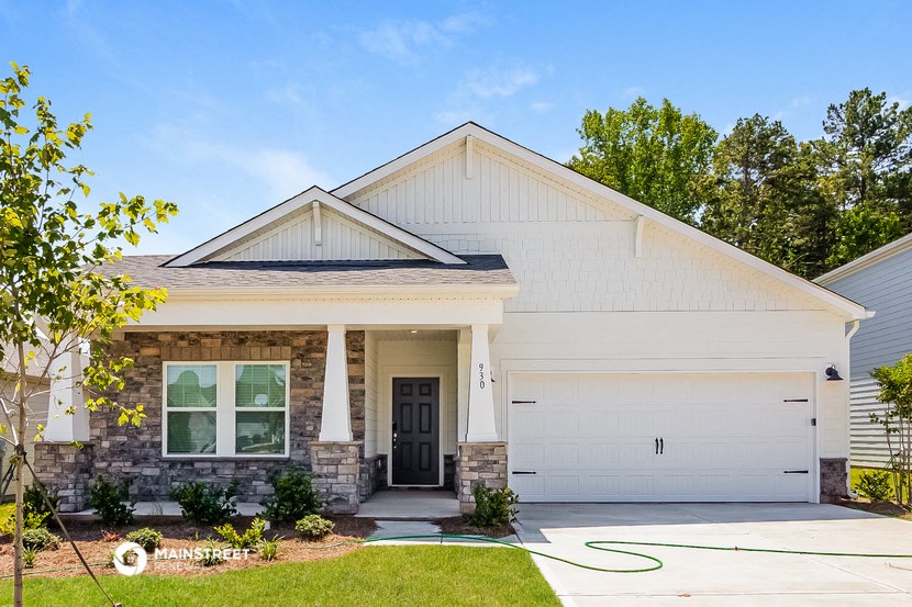 a white house with a black door and a driveway