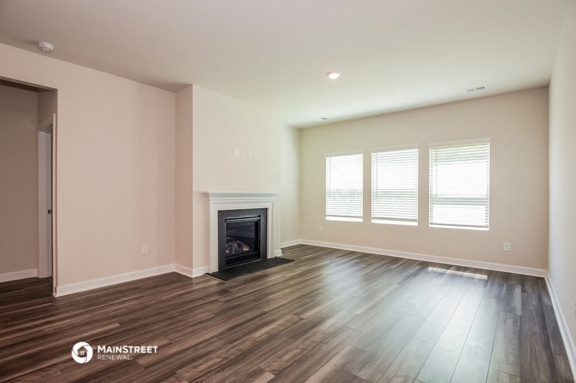 the living room with wood flooring and a fireplace