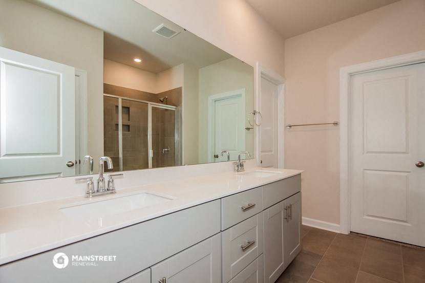 a large white bathroom with a large mirror and two sinks