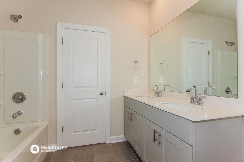 a bathroom with two sinks and a shower and a mirror