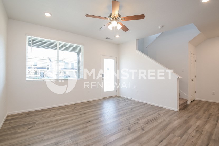 a living room with a ceiling fan and a window