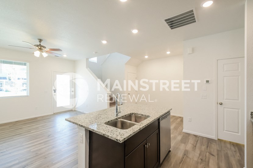 a kitchen with granite countertops and a sink in a renovated apartment