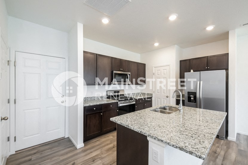 a kitchen with granite countertops and stainless steel appliances