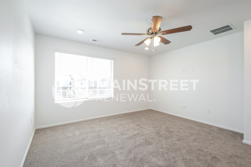 a living room with carpet and a ceiling fan