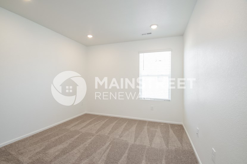 a bedroom with a carpeted floor and a window