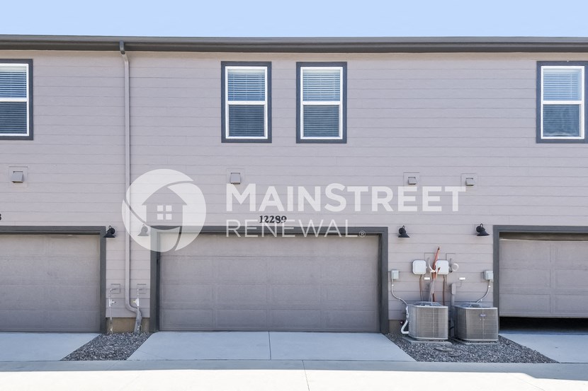 a building with a garage door and a sign on the side of it