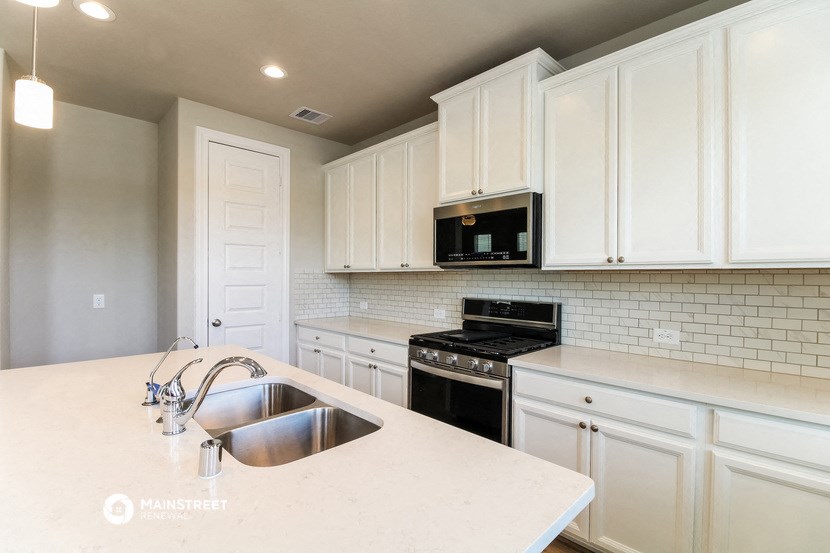 a kitchen with white cabinets and a sink