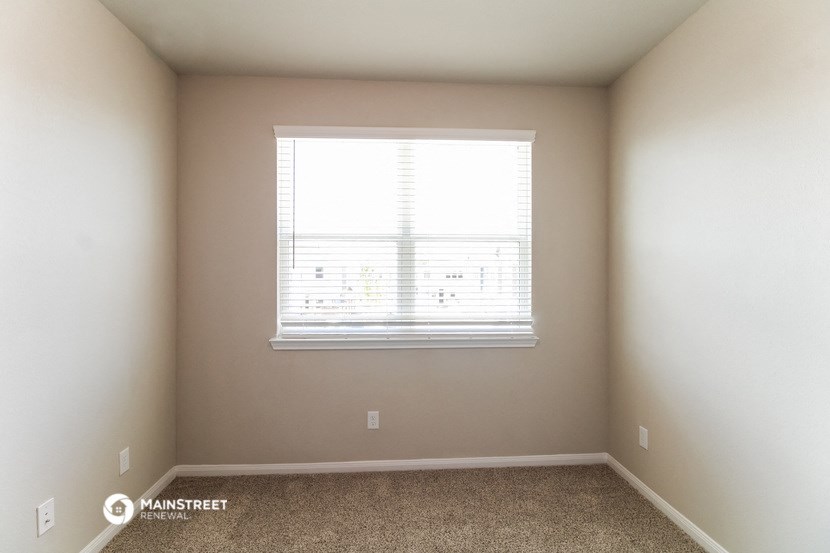 a room with a window and a carpeted floor