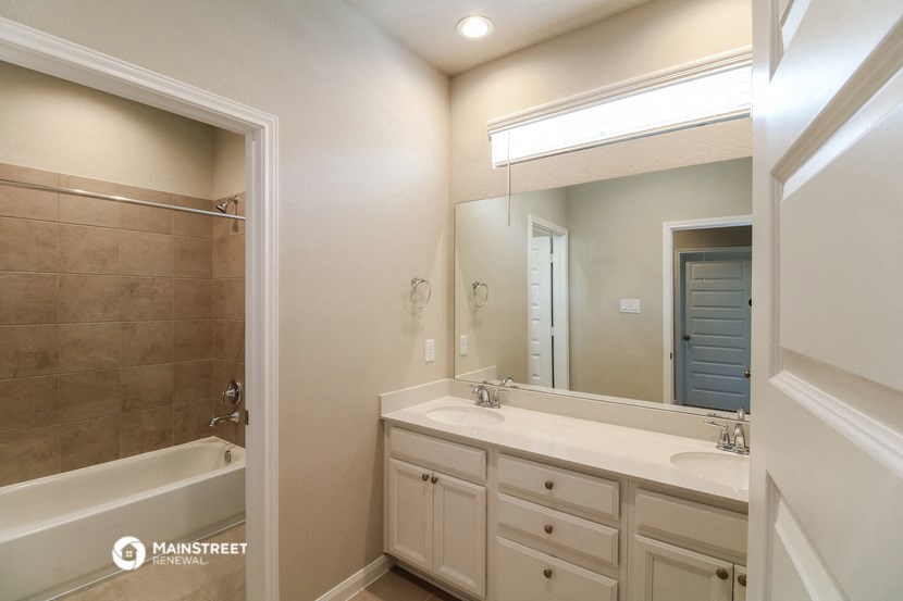 a bathroom with a sink and a tub and a mirror