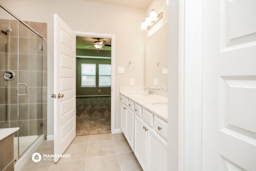 a bathroom with a shower and a sink and a mirror