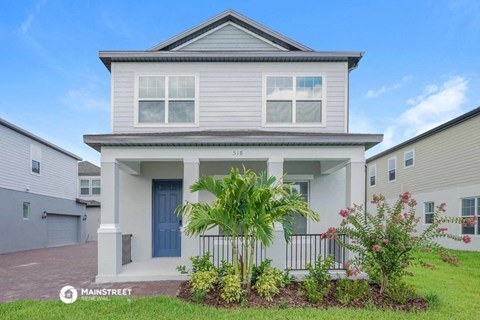 a white house with a blue door and palm trees in front of it