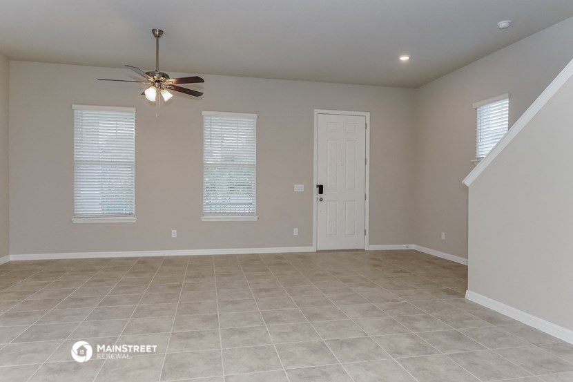 an empty living room with a ceiling fan