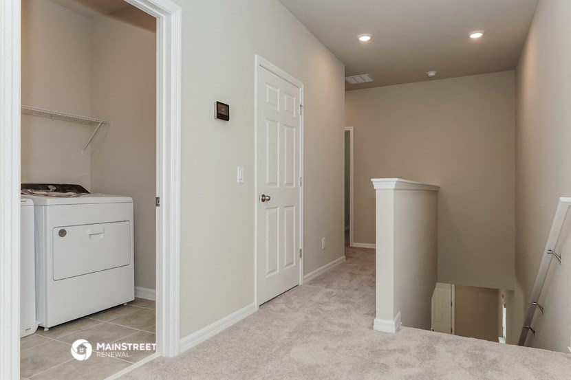 a laundry room with a washer and dryer and a white door