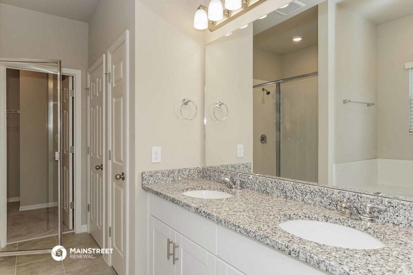 a bathroom with two sinks and a large mirror
