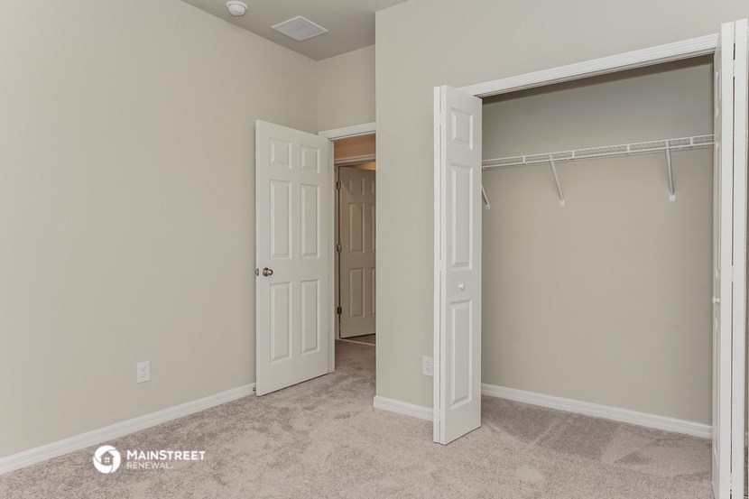 a bedroom with a closet and a door to a bathroom