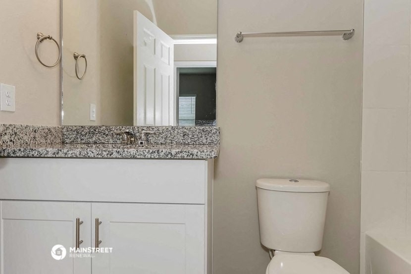 a bathroom with a toilet and a sink and a mirror