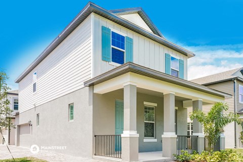 a white house with blue windows and a porch