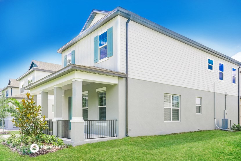 a white house with a green lawn and a blue sky