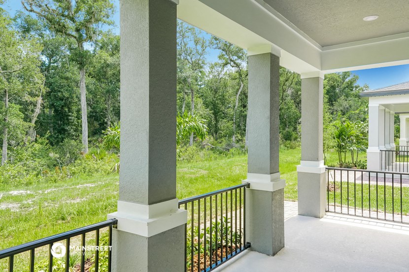 a balcony with a view of a yard and trees