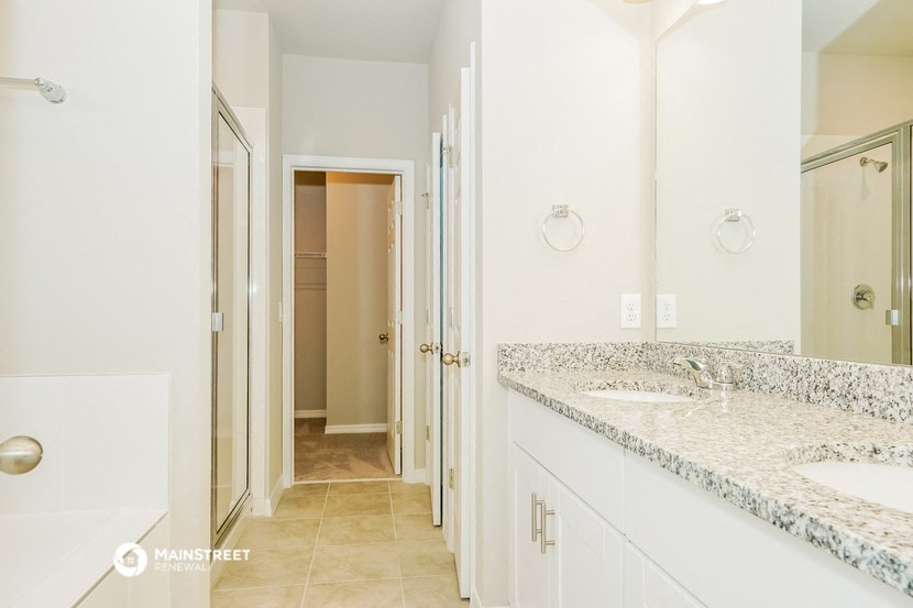 a bathroom with two sinks and a shower and a mirror