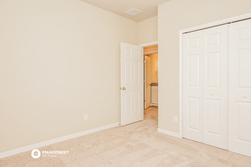 a bedroom with two closets and a door to a bathroom
