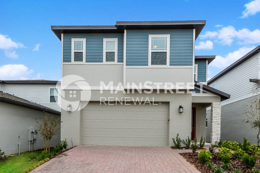 a house with a garage and a driveway in front of it