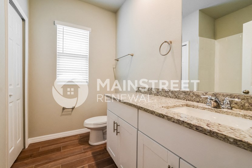 a bathroom with a toilet and a sink and a mirror