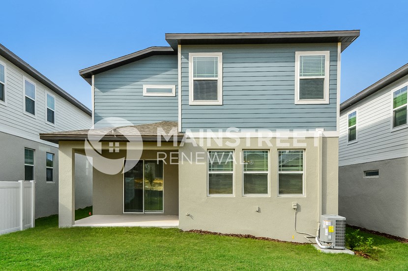 a blue house with a yard in front of it